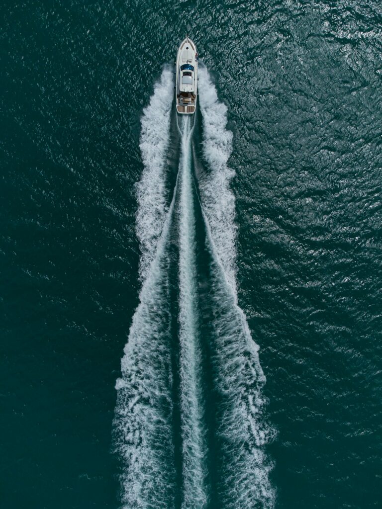 Aerial top down view of speed motor boat on open sea at summer day